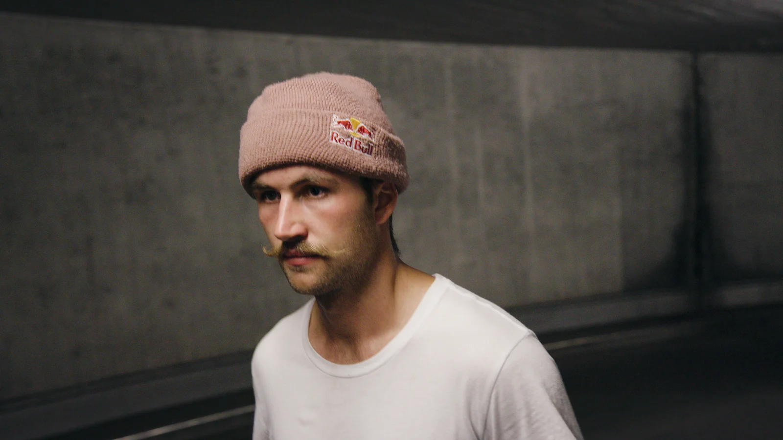 Portrait of the skateboarder Felix Georgii wearing a beanie and white t-shirt